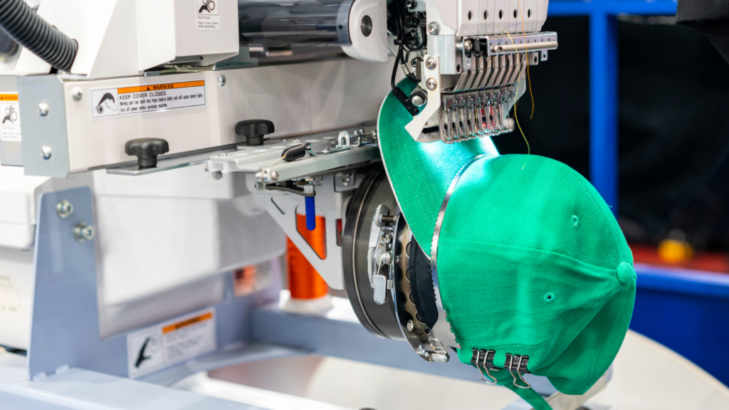 Custom embroidery made easy with POD A green hat is being placed onto a machine, showcasing a unique interaction between the accessory and technology.