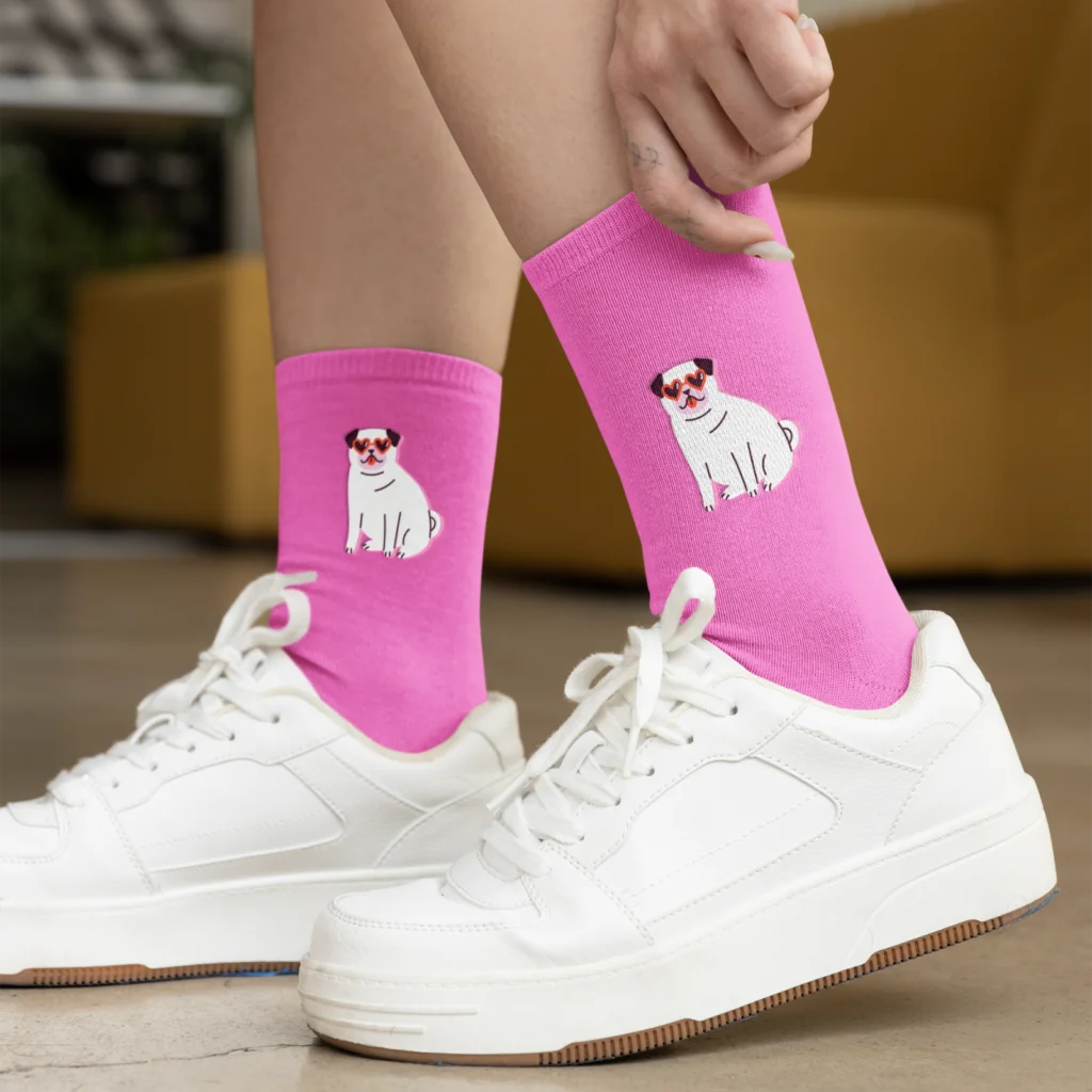 Custom socks A woman wearing white shoes and custom pink socks with a dog illustration print.