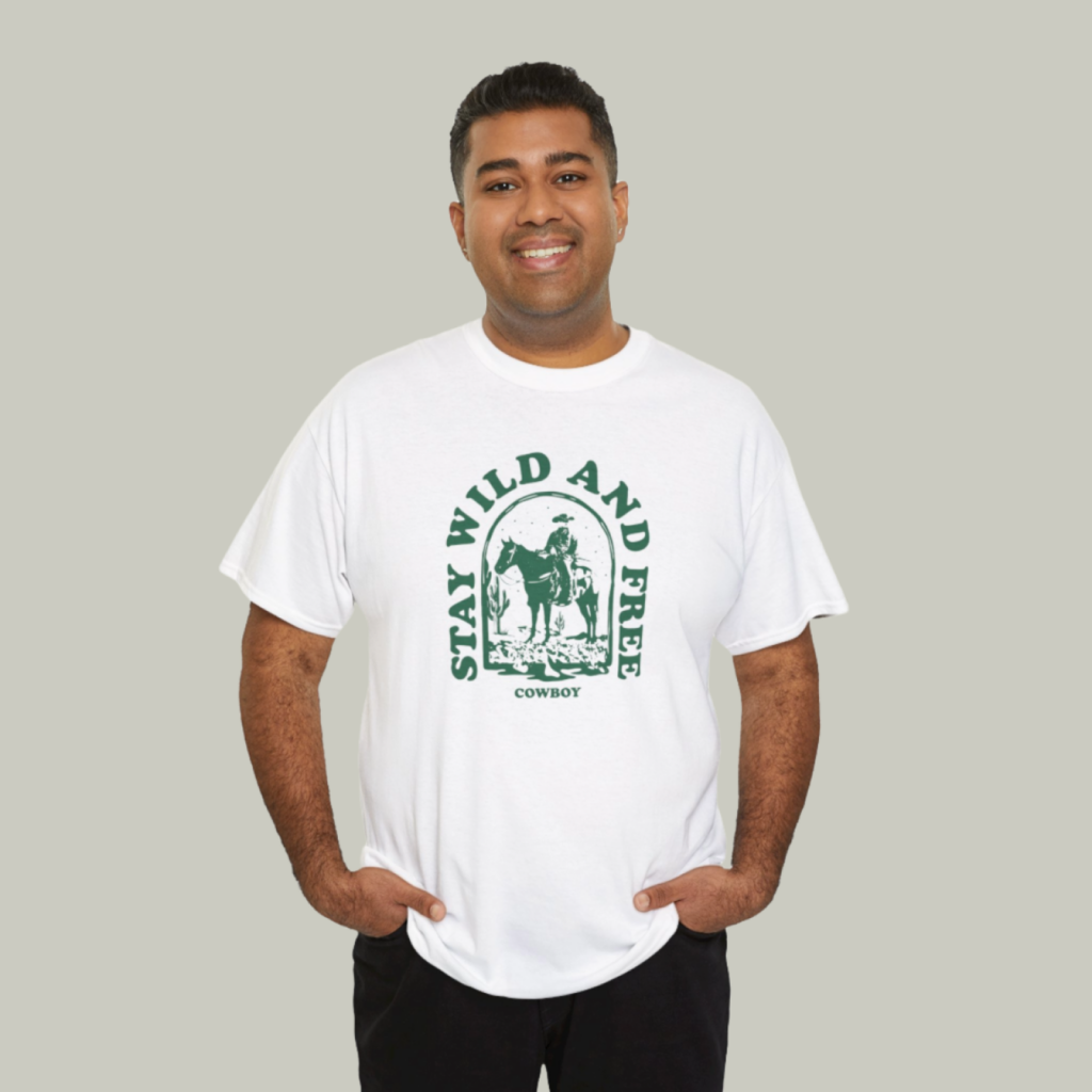 Gildan 5000 unisex heavy cotton tee A mockup of a man wearing a t-shirt with a custom “Stay wild and free” print on a light-green background.