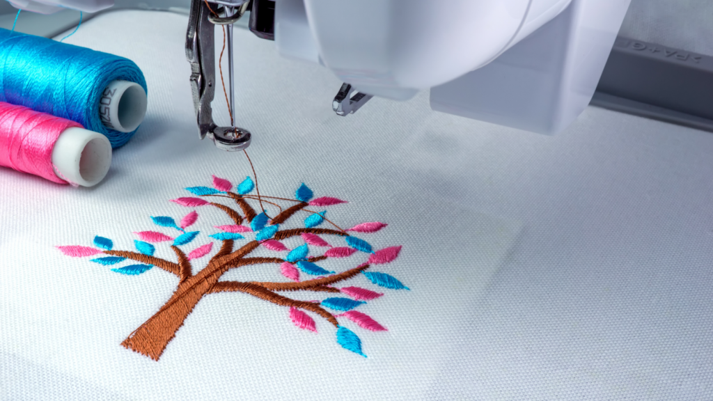 What makes a great embroidery design A sewing machine featuring a beautifully embroidered tree design on its fabric surface.